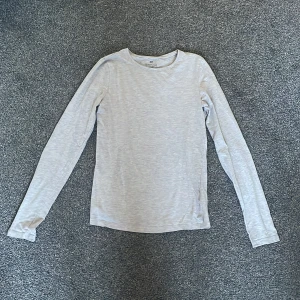 Ljusgrå långärmad tröja från H&M - Säljer en stilren ljusgrå långärmad tröja från H&M. Tröjan är tillverkad i ett mjukt material som ger en skön känsla mot huden. ❤️