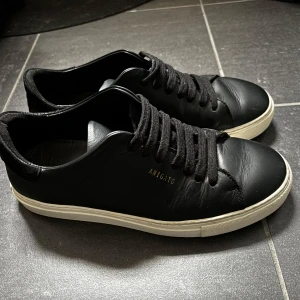 Svarta sneakers från Axel Arigato - Snygga svarta sneakers från Axel Arigato med vit sula och klassisk snörning. Tillverkade i skinn för en stilren look. Perfekta för en minimalistisk stil. 💗💗nypris är 2450