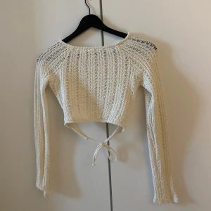 Vit stickad croppad tröja - Vit stickad croptop perfekt till sommaren! Litet hål i ena armhålan men annars i mycket fint skick 