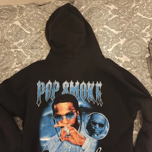 Svart hoodie med Pop Smoke-tryck - Snygg svart hoodie med stort Pop Smoke-tryck på ryggen. Passar både xs för en oversized look men också S-M