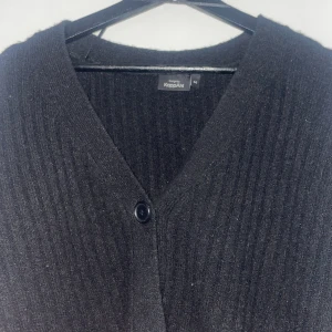 Svart kofta från KappAhl - Fin svart stickad kofta/tröja med knappar och puffiga ärmar. Är i storlek M men skulle säga att den är i S. Använd fåtal gånger.