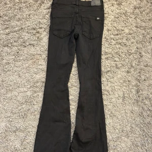 Svarta bootcut byxor från 77thFlea - Snygga svarta bootcut byxor från 77thFlea. De har en klassisk design med dragkedja och knappar framtill. 