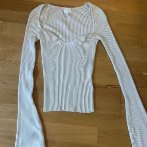 Topp H&M - Fin ribbad topp från H&M med utsvängda ärmar. Endast använd 1 gång. Mycket bra skick.