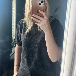 Mörkgrå stickad t shirt - Säljer en superfin mjuk mörkgrå stickad t shirt. Perfekt som ett basplagg i garderoben. Säljer då jag aldrig använt den.                                                    🩶🩶🩶
