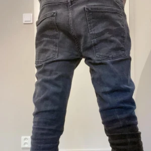 Svarta jeans med fickor - Snygga svarta jeans med stora bakfickor och en cool, lite sliten look. Perfekta för en avslappnad stil. De har en rak passform och är midwaist, vilket gör dem bekväma att bära hela dagen.