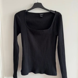 Svart ribbad topp  - Snygg svart ribbad topp från Lindex med långärmad design och fyrkantig halsringning. Perfekt för en stilren look. Passar bra till både jeans och kjol. 🖤