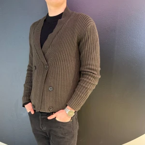 Brun ribbad kofta med knappar - Snygg brun ribbad kofta med knappar framtill. Perfekt för en stilren look med långa ärmar och en bekväm passform. Passar bra till både vardag och mer uppklädda tillfällen.