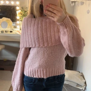 Rosa stickad offshoulder tröja - Säljer en superfin rosa stickad tröja med offshoulder-design. Tröjan har långa ärmar och en bred ribbad kant upptill som ger en snygg look. Perfekt för kyligare dagar och att mysa i hemma. 💖