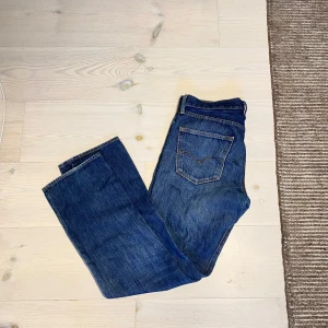 Levis 501 - Säljer dessa svingoa 501or! Klassisk blå färg men lite mer unika då de har fått schyssta slitningar efter användning, utöver det är de i välbehållet skick. Inga hål eller defekter som stör👍 Storlek 32 32 sitter true to size. Passform regular/straight. Skriv om ni har frågor eller prisförslag! 