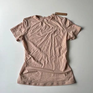 SKIMS t-shirt - SKIMS Fits Everybody t-shirt i färgen Mica, säljs inte längre. Köpt för 656kr (plus frakt), aldrig använd med lappen kvar