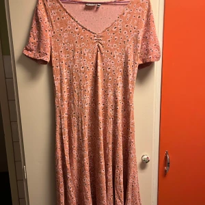 Rosa blommig klänning från Fransa - Säljer en söt rosa klänning från Fransa med blommigt mönster. Klänningen har en v-ringad hals och korta ärmar, perfekt för sommarens varma dagar. Den är både bekväm och stilren, vilket gör den till ett måste i garderoben. 🌸🎀köpt för 540, säljer billigt. 🤗