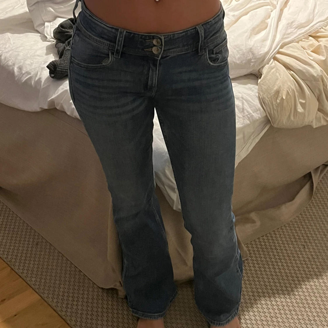 Blå bootcut jeans med knapp fickor där bak - 1