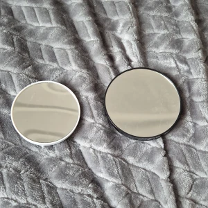 Runda speglar med sugproppar - Två praktiska runda speglar med sugproppar för enkel montering. En spegel har en vit ram och den andra en svart ram. Perfekta för badrum eller andra ytor där du behöver en snabb och enkel spegellösning.