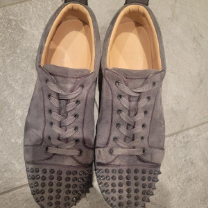 Christian Louboutin - Snygga grå sneakers i mocka från Christian Louboutin med nitar på tån och den ikoniska röda sulan. Priset kan diskuteras. INGA BYTEN. Skriv för mer bilder. Är inne ofta och svarar nästan direkt.