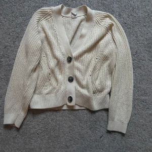 Beige stickad kofta med knappar - Trendig beige stickad kofta, som är perfekt till våren! Skulle säga att den passar storlek xxs!