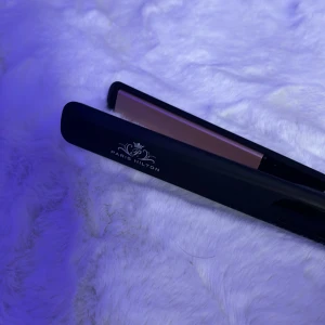 Plattång från Paris Hilton - Snygg och stilren plattång från Paris Hilton med svart och rosa design. Perfekt för att skapa släta och eleganta frisyrer. Den är lätt att använda och har en modern look.