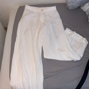 Vita linnebyxor - Snygga luftiga vita linnebyxor med rak passform. Byxorna har en knapp och dragkedja framtill. Dom är från H&M och  använda någon enstaka gång. Storlek: 34/XS