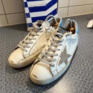 Golden Goose skor  - Hej! Ett par galet snygga Golden Goose skor i toppen skick, med ljusblå detalj bak i hälen. Storlek 42 passar större. Allt og följer med 