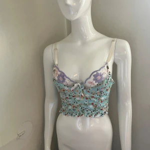 Blommig spets bustier / korsett / linne - Köpt från plick men knappt använd av mig då jag inte riktigt tycker materialet är bekvämt. Gullig med spets, blommor och broderi och knäppning med hyskor där bak. 🌸🌸