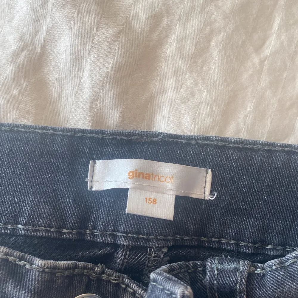 Ett par gråa jeans med fickor där bak. Jeans & Byxor.