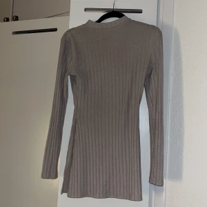 Beige ribbad tröja - Säljer en stilren och bekväm beige ribbad tröja. Den har en normal passform med långa ärmar, perfekt för både vardag och lite kyligare dagar. Tröjan är i ett mjukt material som känns skönt mot huden.