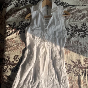 Vit klänning med spets och snörning  - Så fin klänning, ny med prislapp hann bara inte lämna tillbaka. Lite sminkfläckar på (?) som var där när jag fick hem den från Zara, går med största sannolikhet bort i tvätten