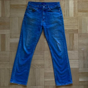 Blå jeans med slitningar - Blå snygga jeans från Red Rock! Slitna på baksidan vid hälarna (se bild 2) och litet hål framtill på ena knät (se bild 4), men i övrigt i fint skick. 