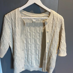 Kofta med knappar och korta armar - En jätte fin stickad kofta med knappar med korta armar❤️jätte fint skick från Holly and white by lindex i storlek s, skriv om ni undrar nått! Den är kräm vit/ beige 