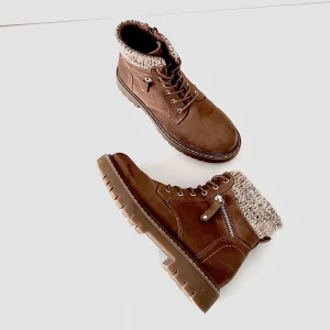 Bruna kängor med stickad kant - Säljer ett par snygga bruna kängor med en mysig stickad kant upptill från Landrover. De har en rejäl sula med bra grepp och snörning framtill. Perfekta för höst och vinter! Höger sko har ett litet mörkt märke. Vänster sko insida har ett litet ljust skav. Frakt tillkommer.