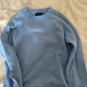 Ljusblå stickad tröja från Vero Moda - Säljer en supermysig ljusblå stickad tröja från Vero Moda. Perfekt för kyliga dagar med sin mjuka och varma känsla. Tröjan har långa ärmar och en rund halsringning. Den är i nyskick och redo för att bli en del av din garderob! 💙