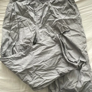 Grå och svarta mjukisbyxor - Säljer ett gäng sköna parachute pants i olika nyanser av grått och svart. De har en elastisk midja för extra komfort och är gjorda i ett mjukt material. Byxorna är lite skrynkliga eftersom nytvättade men skickar dom i bättre skick👍 alla 4 par för 300kr