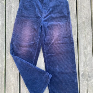 Weekday manchester byxa - Mjuk, bred manchester byxa från Weekday. Mörk blå med vinröd blekt på knä. Bra kvalité.  Bilderna tagen i stark solljus: byxan är mörkare blå än på bild. 