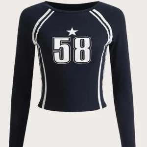Svart långärmad topp med nummer 58 - Snygg svart långärmad topp med ett stort tryck av siffran 58 och en stjärna ovanför. Den har vita detaljer längs ärmarna och sidorna som ger en sportig look. Perfekt för en casual dag eller en avslappnad festkväll!