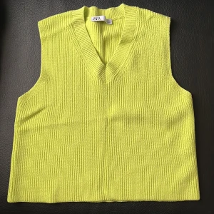 väst från Zara - Säljer en snygg gul stickad väst från Zara. Den har en v-ringad design och är perfekt för lager-på-lager under hösten. Västen är i nyskick och passar bra till både vardag och fest. Perfekt för att lysa upp din outfit! 