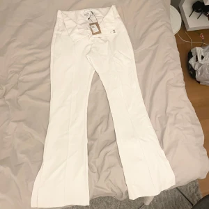Vita kostymbyxor  - Jätte fina utsvängda vita kostymbyxor med slits från bershka men köpt från sellpy i storlek 38, säljes då de aldrig använts.