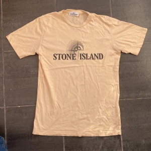 Stone Island t - shirt - Säljer nu denna riktigt snygga stone Island t shirt i färgen aprikos. T shirten är i mycket bra skick. Nypris kostar den ca 1000 Tröjan är köpt på NK för några år sedan alltså är den äkta och är i storlek 170 cm / 14 år. OBS priset går att ändra på.