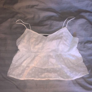 Söt topp - Säljer en söt vit ärmlös topp från Shein i storlek XS. Toppen har tunna axelband och ett fint broderat blommönster. Perfekt för sommardagar eller en avslappnad fest. Den är lätt och luftig, vilket gör den idealisk för varma väder. Knappt använd!! Pris kan diskuteras🫶🏻