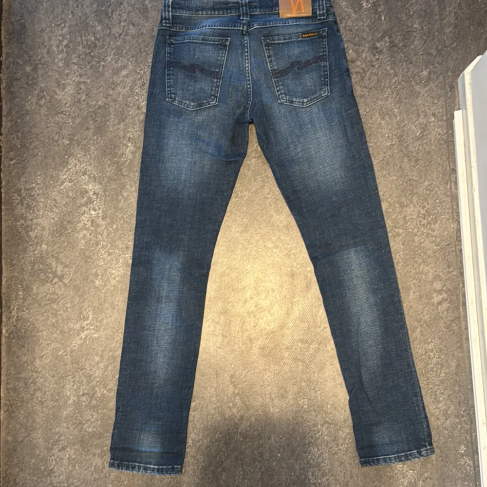 Säljer ett par snygga blå jeans från Nudie. De har en klassisk femficksdesign och en bekväm passform. Storlek 29/32 och modellen är ”Tight Long John”☑️. Jeans & Byxor.