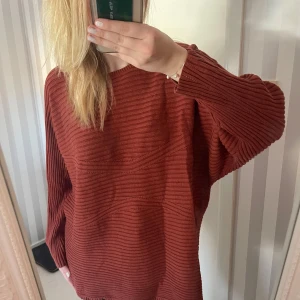 Brun ribbad tröja - Säljer en supermysig röd ribbad tröja med en loose passform. Perfekt för höst och vinter med sina långa ärmar och bekväma design. Den är i nyskick och redo att bli en del av din garderob!