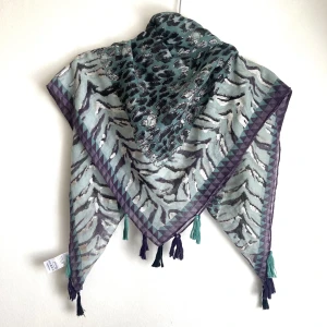 Turkos & lila djurmönstrad tunn sjal, scarf, leopard, zebra, silver metallic, tofsar, bohemisk, boho - Tunn vävd sjal i turkost och lila med silvertryck, tofsar i hörnen. Mått: 92x93 cm.