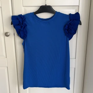 Ribbad t-shirt med volang  - Aldrig använd 