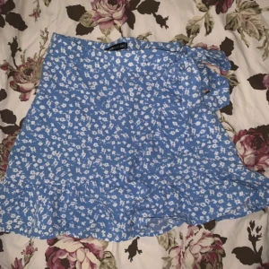 Blå kjol med vita små blommor och dragkedja på sidan - Använd typ 2 gånger. 