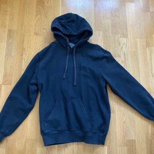 Carhartt svart hoodie - Carhartt hoodie i bleksvart färg. Färgen ser du bäst på sista bilden. Nyskick då den endast är använd enstaka gång. Nypris 999kr.