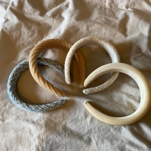 Fyra stiliga diadem i olika färger - Säljer fyra snygga diadem i olika färger och mönster. Perfekta för att piffa upp vilken outfit som helst! De är i beige, brun, blå och grå nyanser med olika texturer. Passar både till vardag och fest. Ett måste för alla som älskar accessoarer!