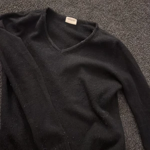 Svart tröja från VILA - Säljer en stilren svart tröja från VILA med v-ringning. Tröjan har långa ärmar och strl xs nopprig är den men inget som märkts så mycket när man har på sig den .