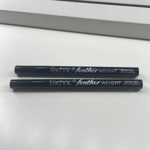Technic Feather Weight Brow Pen - Två stycken Technic Feather Weight Brow Pen för att skapa naturligt definierade ögonbryn. Pennorna har en smidig spets för precis applicering och ger en fjäderlätt känsla. Perfekt för att fylla i och forma brynen med ett långvarigt resultat. Färgen är dark Brown och är aldrig använda. Skriv privat för fler bilder. 55 kr för båda. Nypris 49/styck 