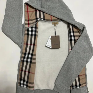 Burberry Zip Hoodie - Säljer en snygg Burberry Zip Hoodie i nästan ny skick 9.5/10✅Tröjan är storlek L men passar M också✅Hör av er vid frågor och funderingar🤩🤝