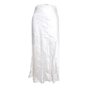 Vit långkjol från H&M Divided - Elegant vit långkjol från H&M Divided i ett glänsande material. Perfekt för en stilren look med sin enkla design och långa längd. Kjolen har en slät yta och en bekväm passform.