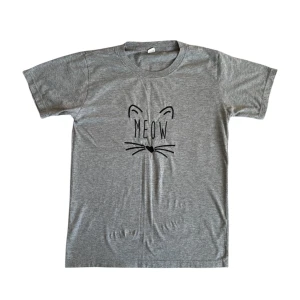 Grå t-shirt med kattmotiv - Grå t-shirt med kattmotiv och texten "Meow". Perfekt för kattälskare eller en avslappnad, lekfull stil!
