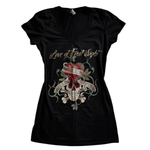 Edgy Rock Tee - Svart v-ringad t-shirt med tatueringsinspirerat tryck. Perfekt för en rockig look!🤘